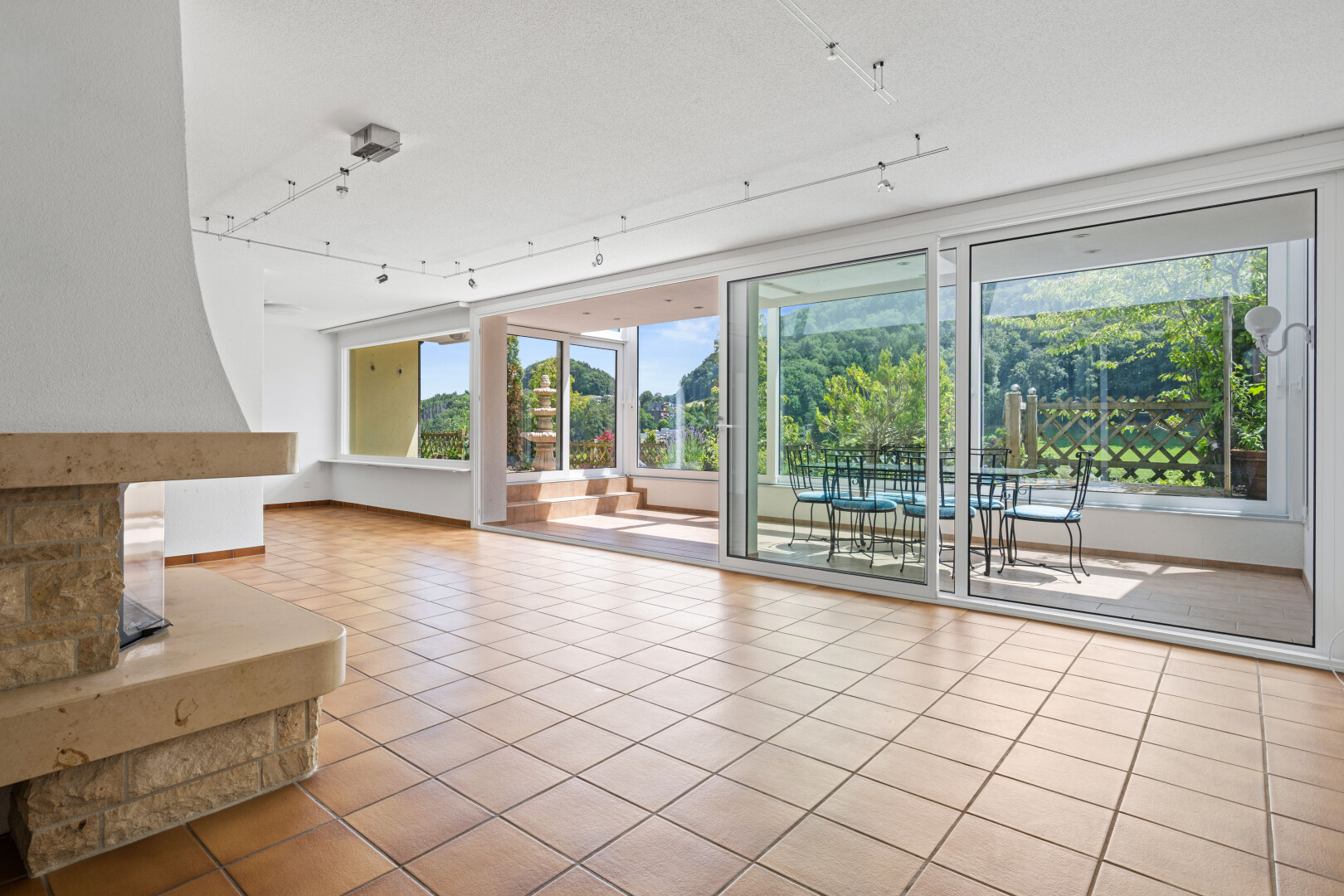 unfurnished living room with track lighting and light tile patterned floors