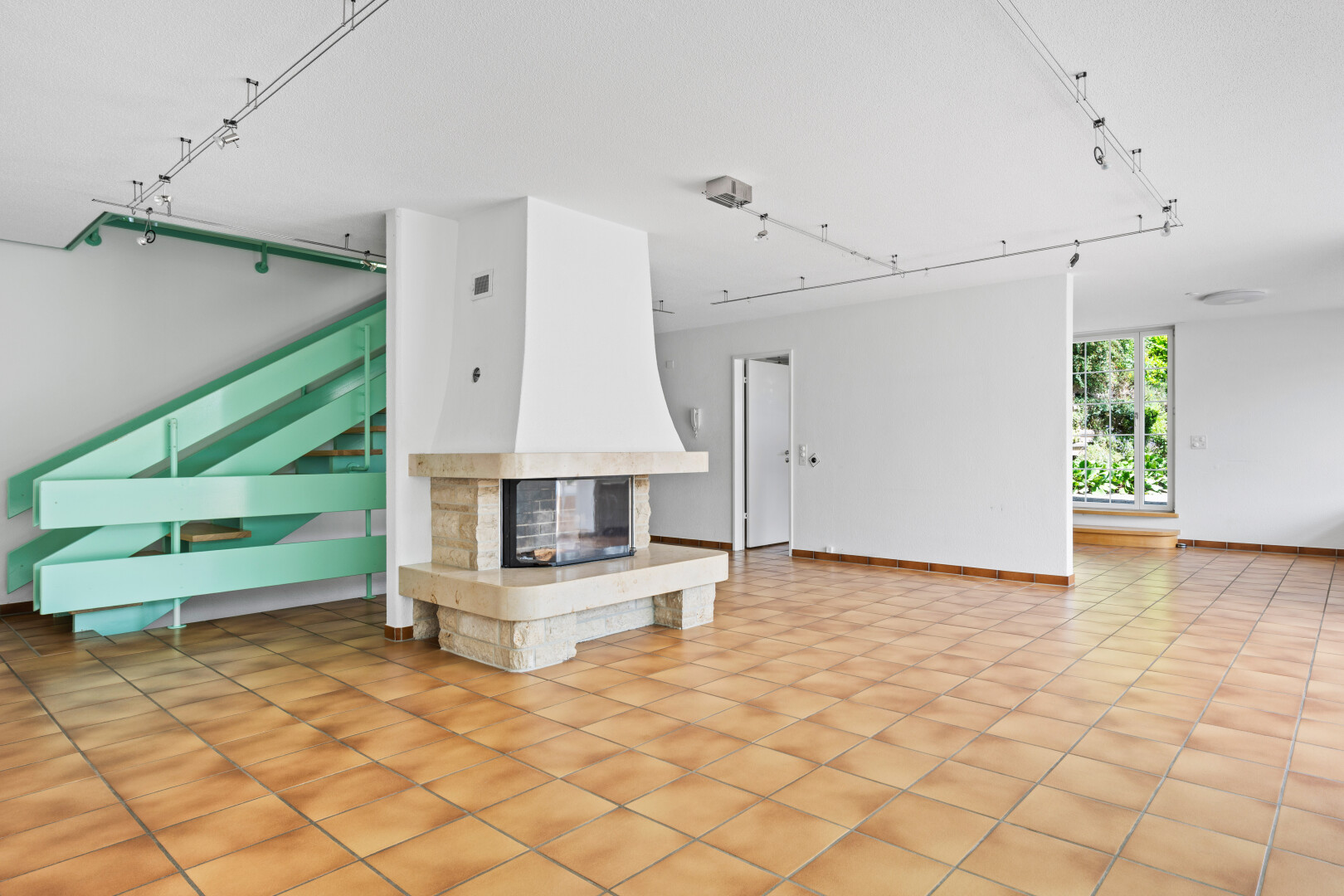 unfurnished living room featuring rail lighting, a multi sided fireplace, and light tile patterned floors