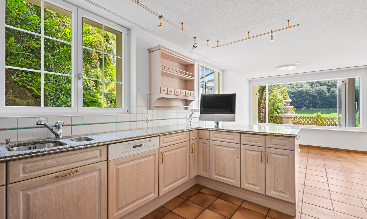 kitchen with light stone counters, healthy amount of natural light, tasteful backsplash, and rail lighting