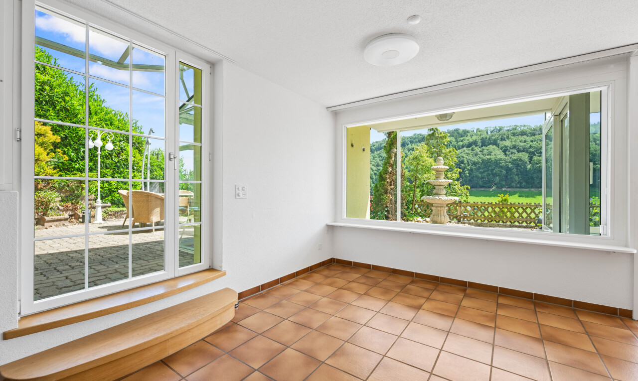 tiled empty room featuring baseboards