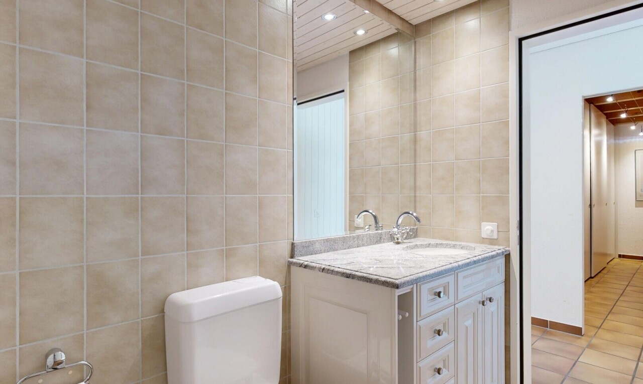 salle de bains avec mur en carrelage, tile wall, éclairage encastré, recessed lighting, et lavabo (ou coiffeuse selon le contexte)