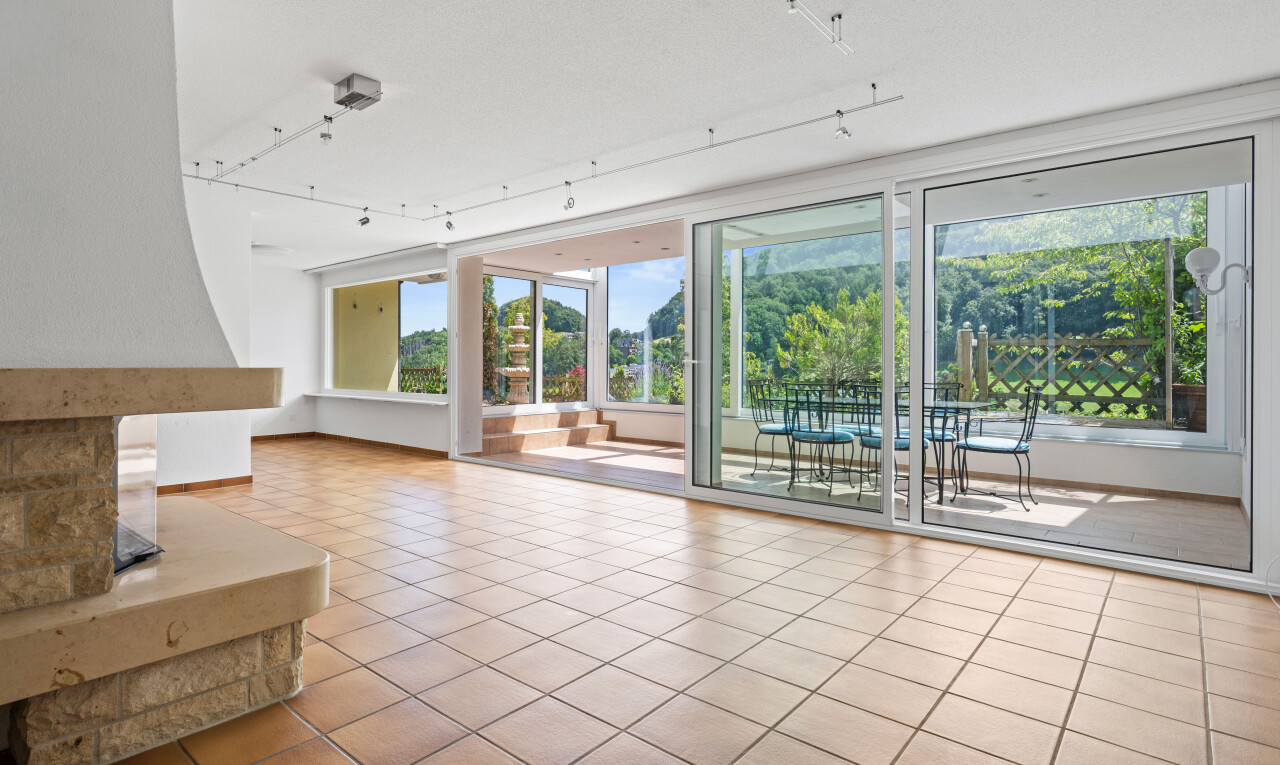 unfurnished living room with track lighting and light tile patterned floors