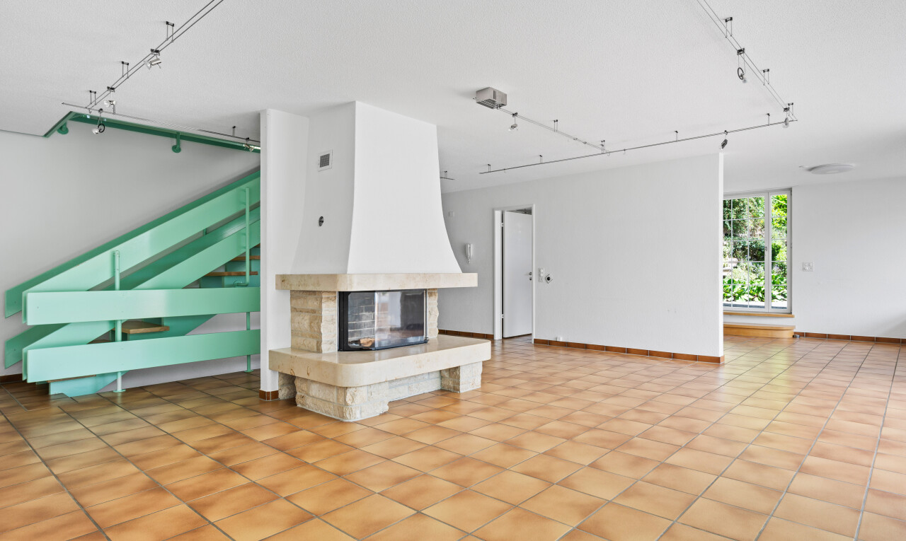 unfurnished living room featuring rail lighting, a multi sided fireplace, and light tile patterned floors