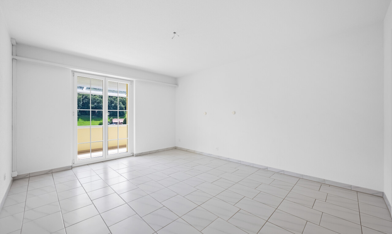 empty room featuring light tile patterned flooring and baseboards