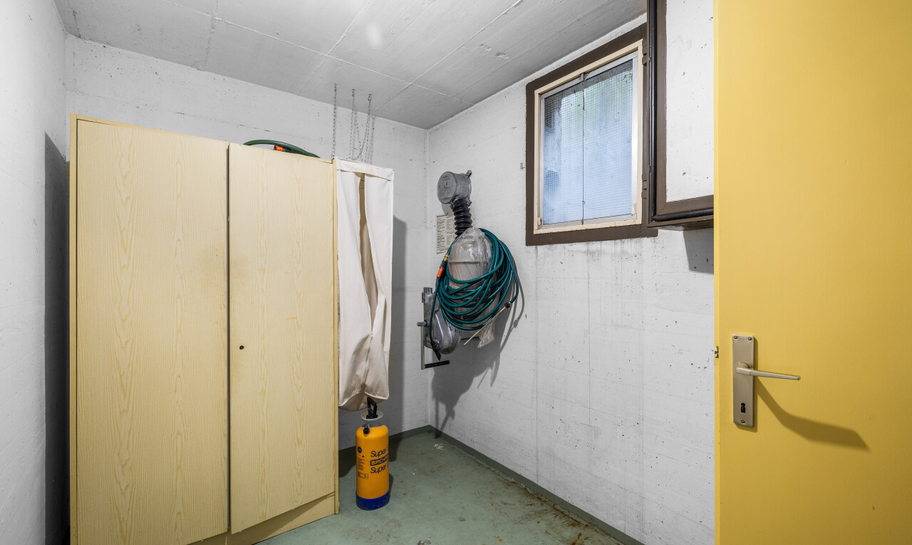 buanderie avec concrete floor, sol en béton, inside property, light floor, et concrete wall