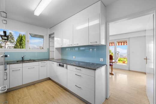 cuisine avec day time, dark countertops, white cabinets, armoires blanches, et light floor