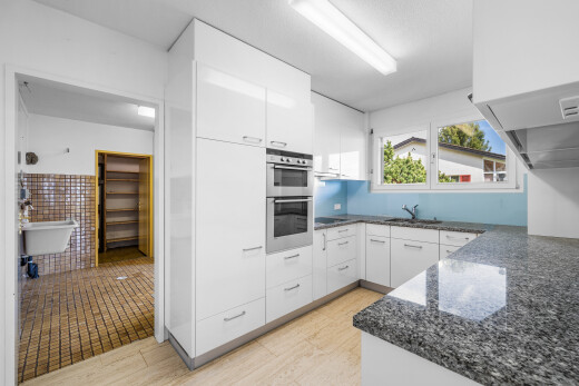 cuisine avec dark countertops, armoires blanches, white cabinets, light floor, et plans de travail en pierre