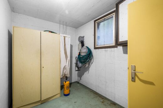 buanderie avec concrete floor, sol en béton, inside property, light floor, et concrete wall