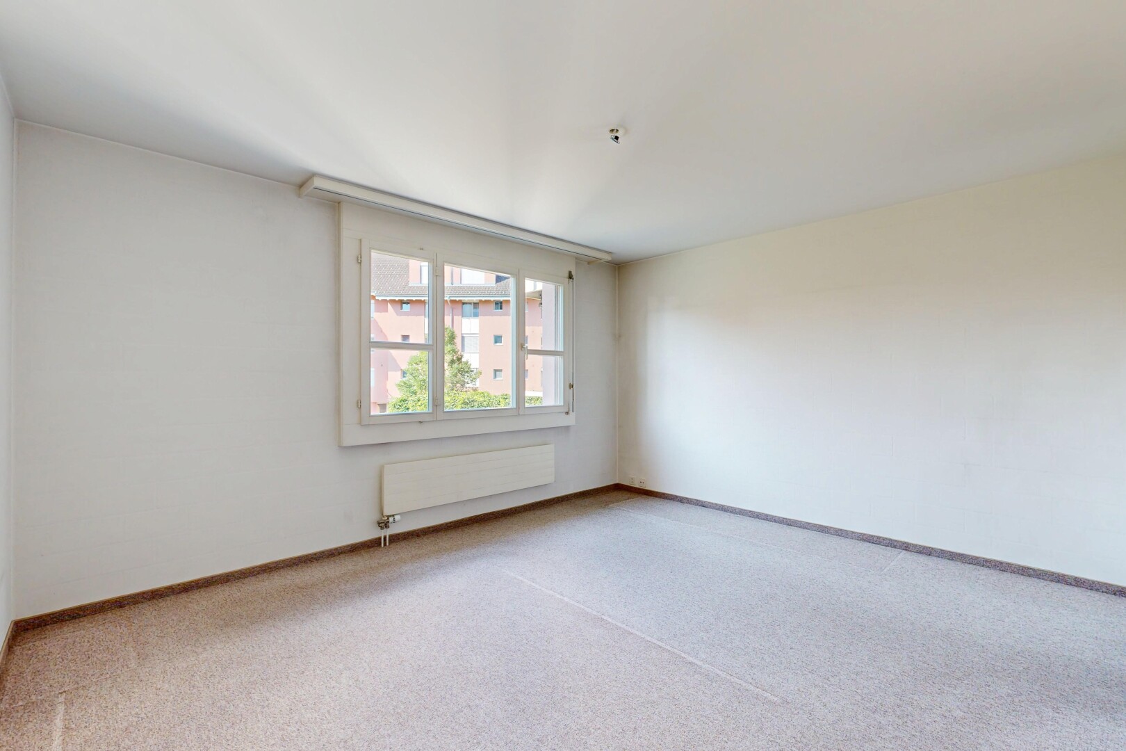 spare room with carpet and radiator heating unit