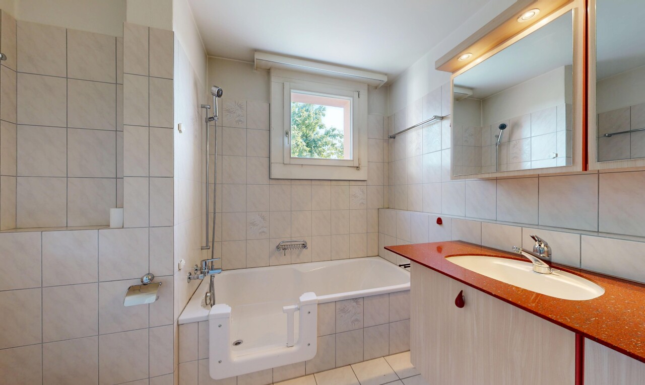 bathroom with vanity, tile walls, tiled shower / bath, and light tile patterned flooring