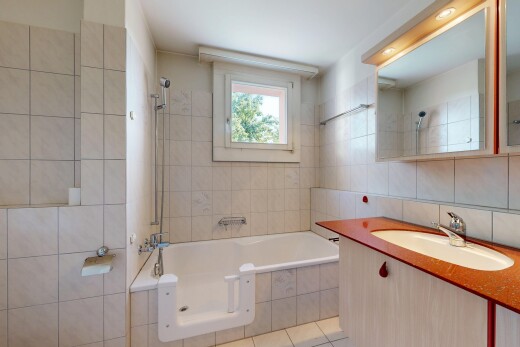 bathroom with vanity, tile walls, tiled shower / bath, and light tile patterned flooring