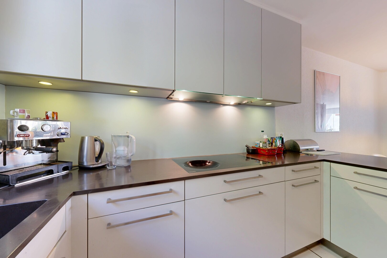 kitchen with dark countertops, electric cooktop, a peninsula, and modern cabinets
