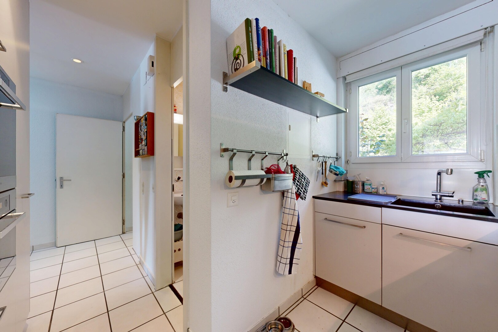 kitchen with white cabinetry, dark countertops, light tile patterned flooring, and open shelves