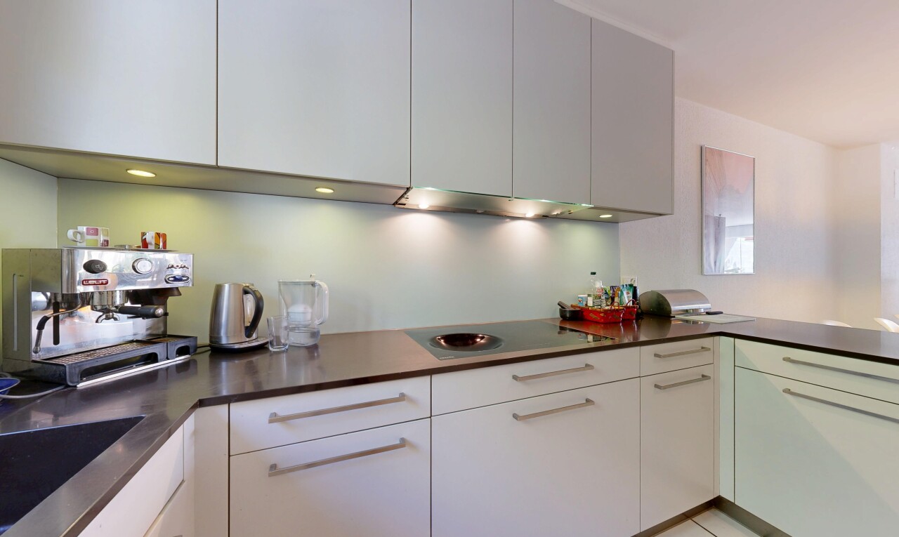 kitchen with dark countertops, electric cooktop, a peninsula, and modern cabinets