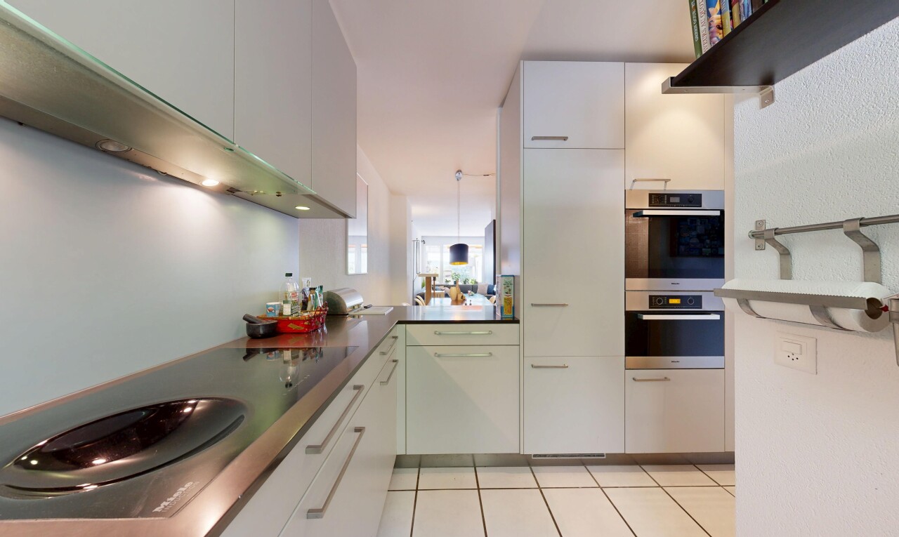kitchen with electric stovetop, double oven, dark countertops, light tile patterned floors, and white cabinetry