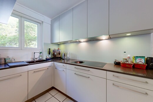 cuisine avec plans de travail, dark countertops, light floor, inside property, et évier