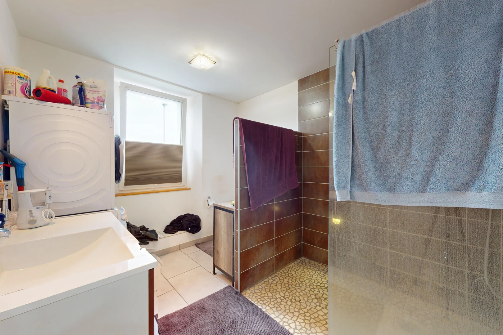 bathroom featuring washer / clothes dryer, vanity, tile patterned flooring, and tiled shower