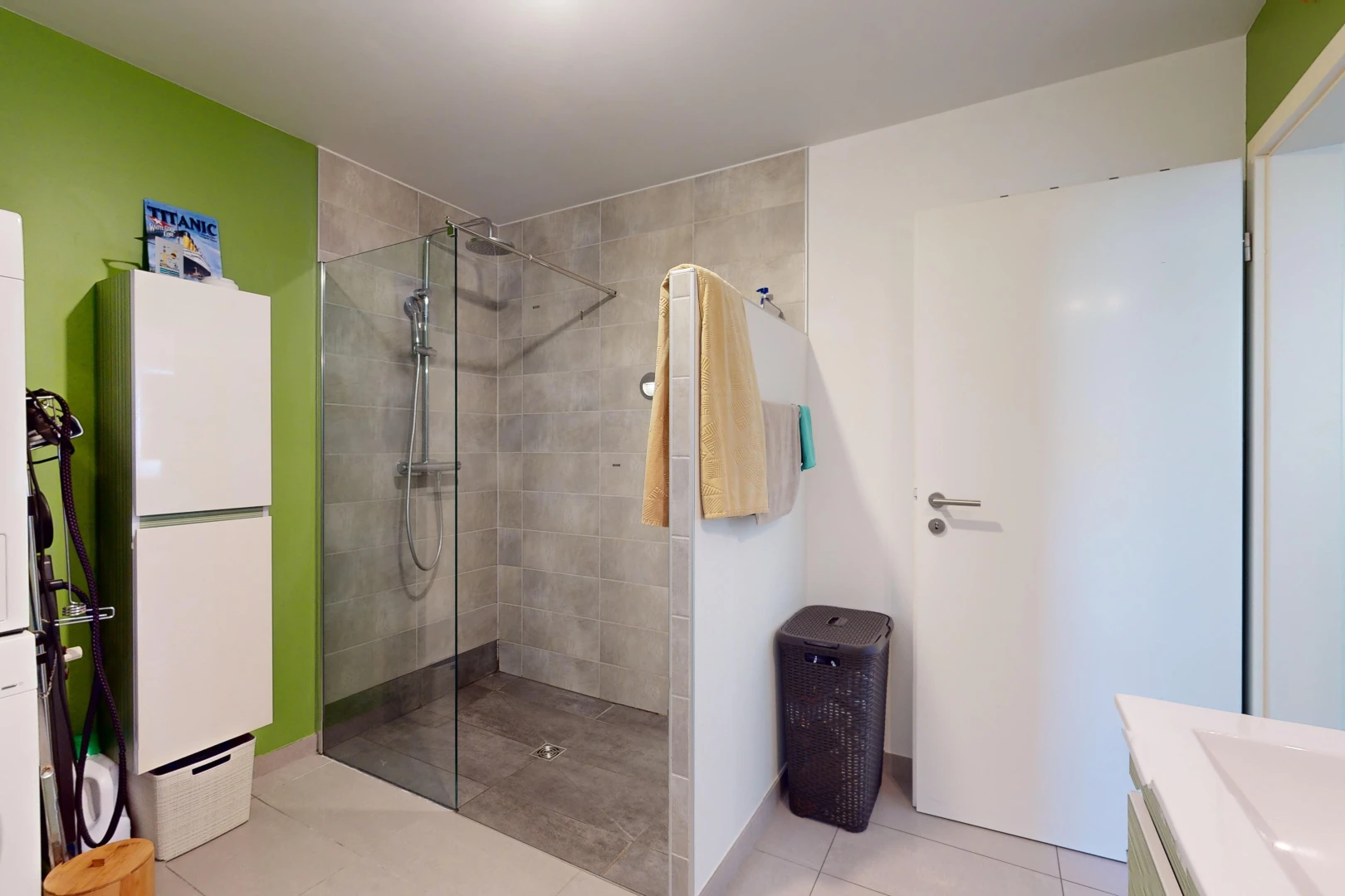 bathroom featuring tile patterned flooring, vanity, and tiled shower