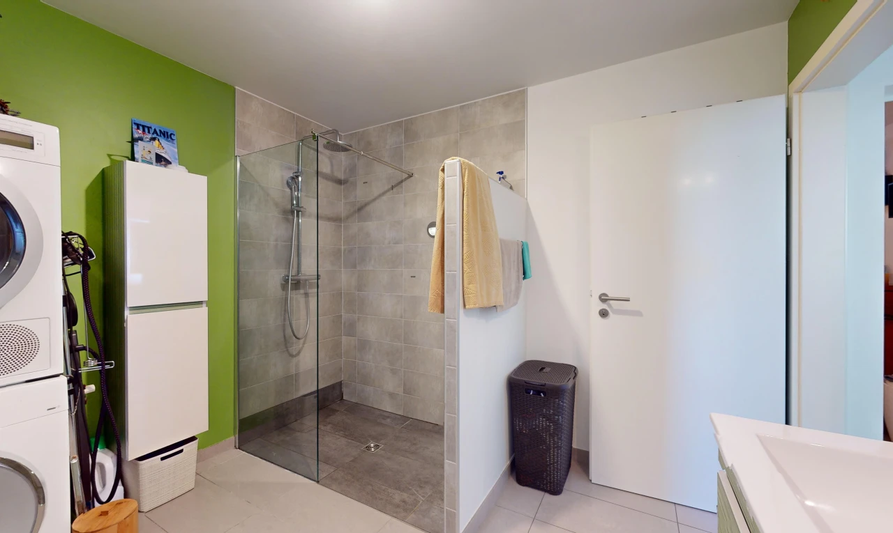 bathroom featuring tile patterned flooring, vanity, and tiled shower
