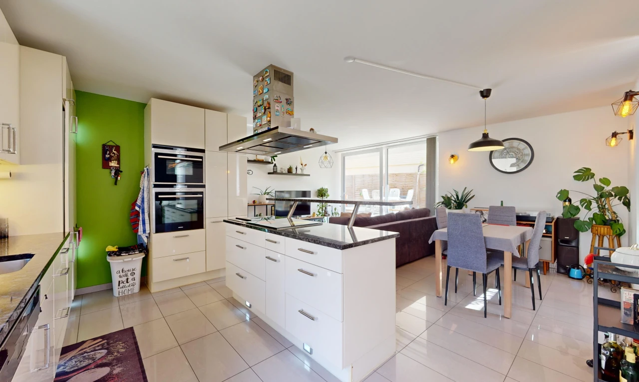 kitchen with stainless steel double oven, light tile patterned flooring, hanging light fixtures, and wall chimney range hood