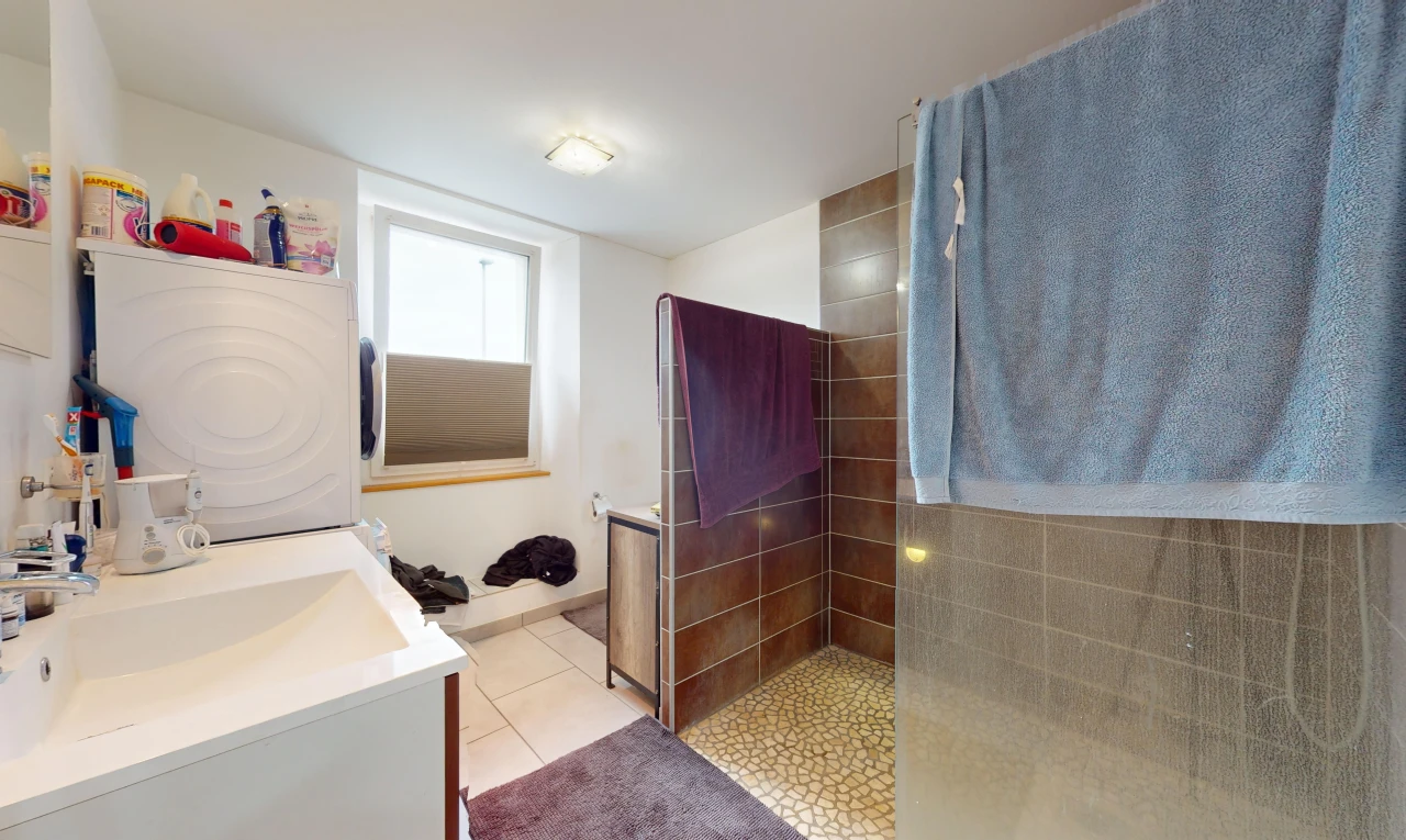 bathroom featuring washer / clothes dryer, vanity, tile patterned flooring, and tiled shower