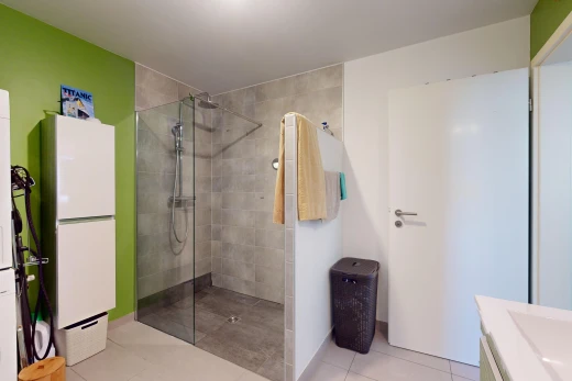 bathroom featuring tile patterned flooring, vanity, and tiled shower