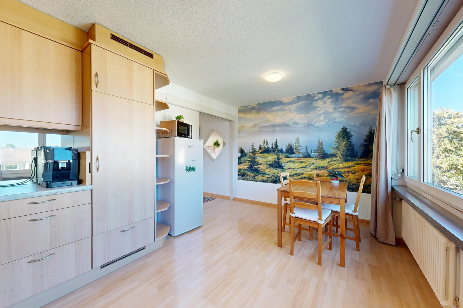 cuisine avec armoires marron clair, light brown cabinets, radiateur, étagères ouvertes, et light floor