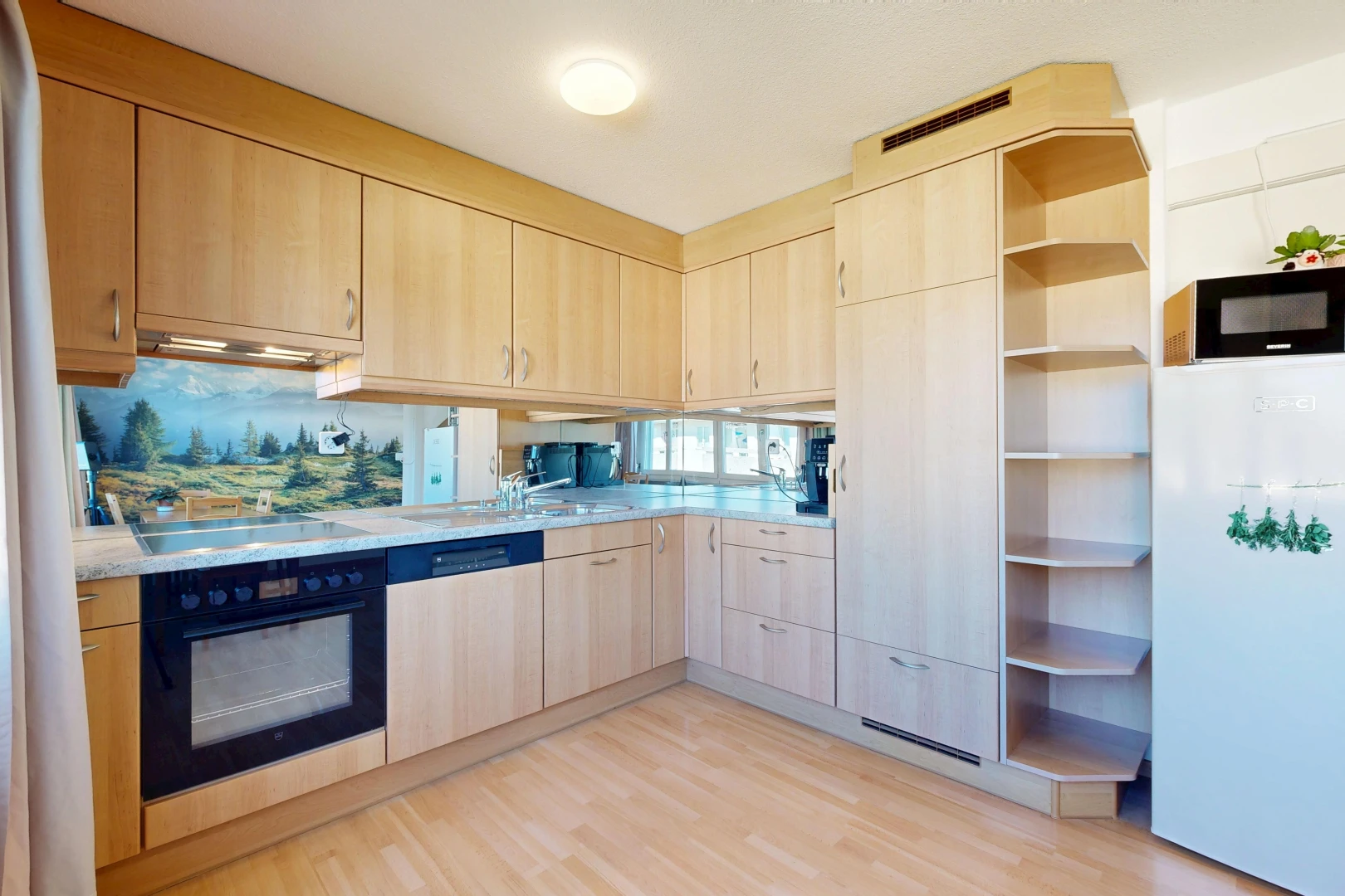 cuisine avec armoires marron clair, light brown cabinets, light countertops, réfrigérateur, et light floor