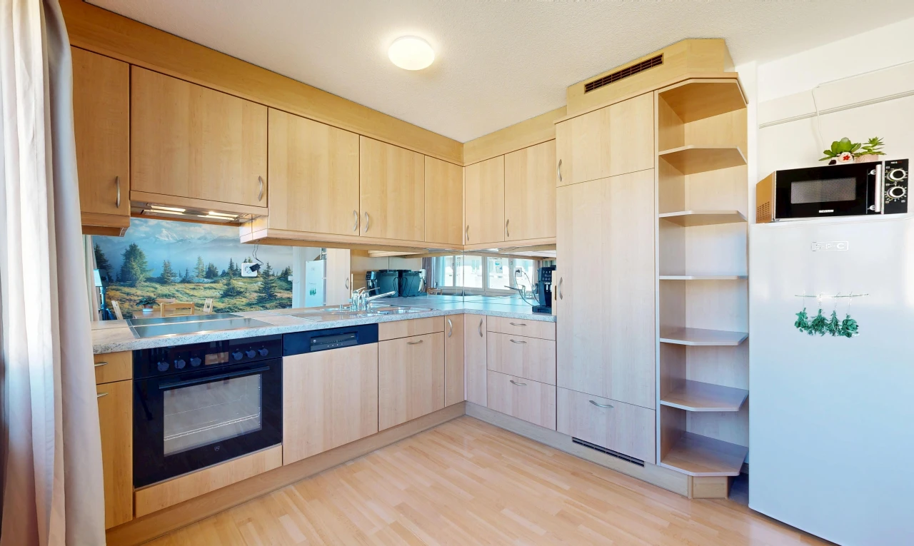 cuisine avec armoires marron clair, light brown cabinets, light countertops, réfrigérateur, et light floor