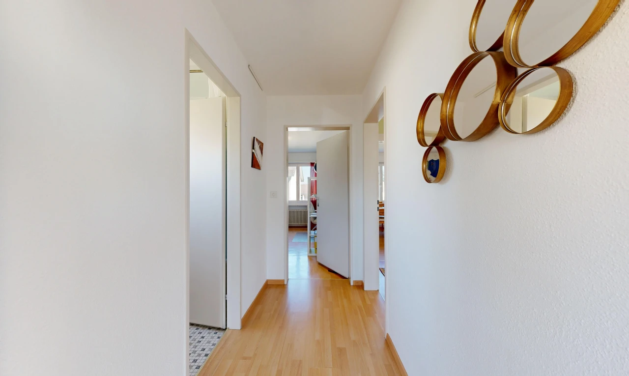 couloir avec inside property, light floor, wood finish floor, sol en finition bois, et drywall