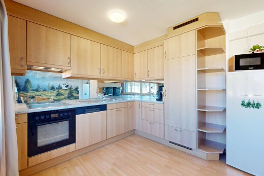 cuisine avec armoires marron clair, light brown cabinets, light countertops, réfrigérateur, et light floor