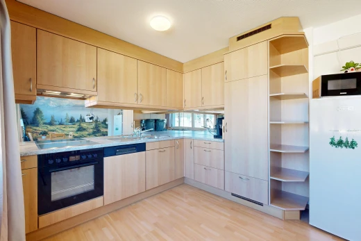 cuisine avec armoires marron clair, light brown cabinets, light countertops, réfrigérateur, et light floor
