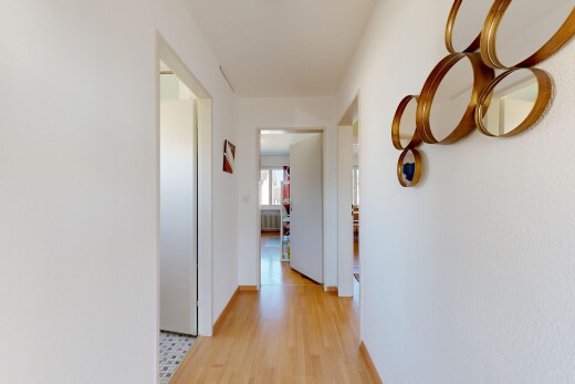 couloir avec inside property, light floor, wood finish floor, sol en finition bois, et drywall