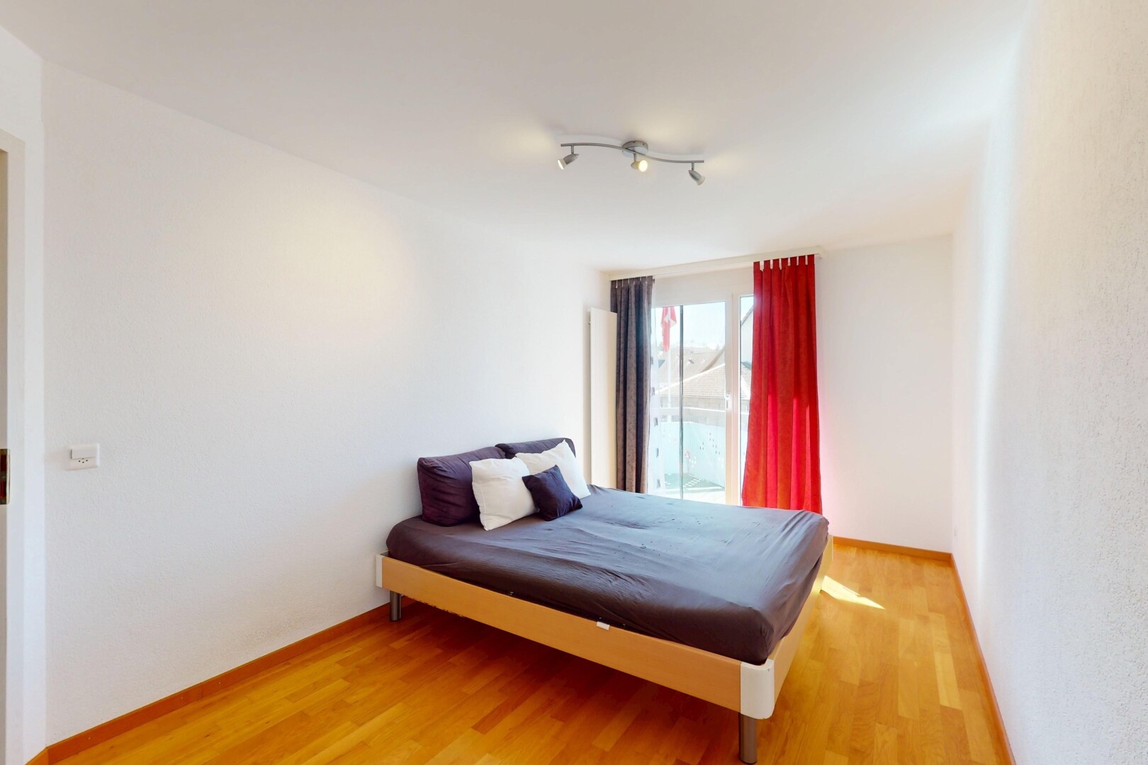 chambre avec lumière naturelle, plinthes murales, sol en finition bois, et cloison sèche