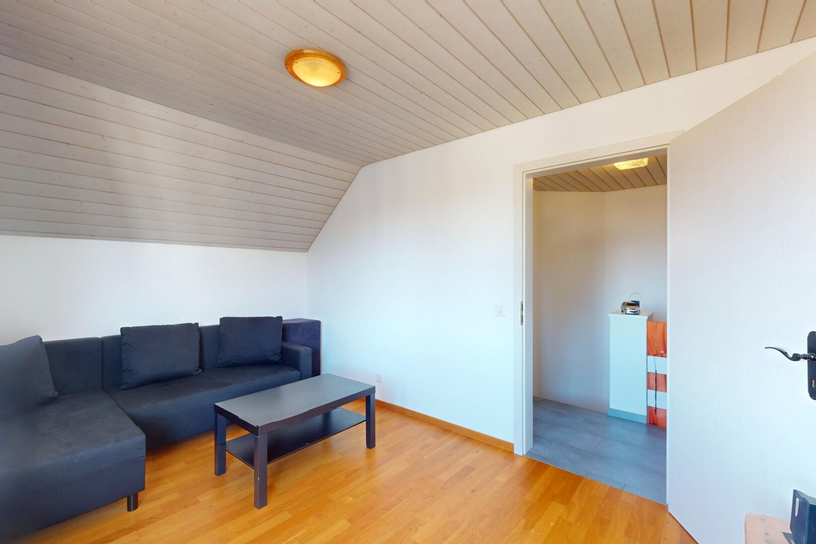 salon avec cloison sèche, plafond en bois, sol en finition bois, et plafond voûté