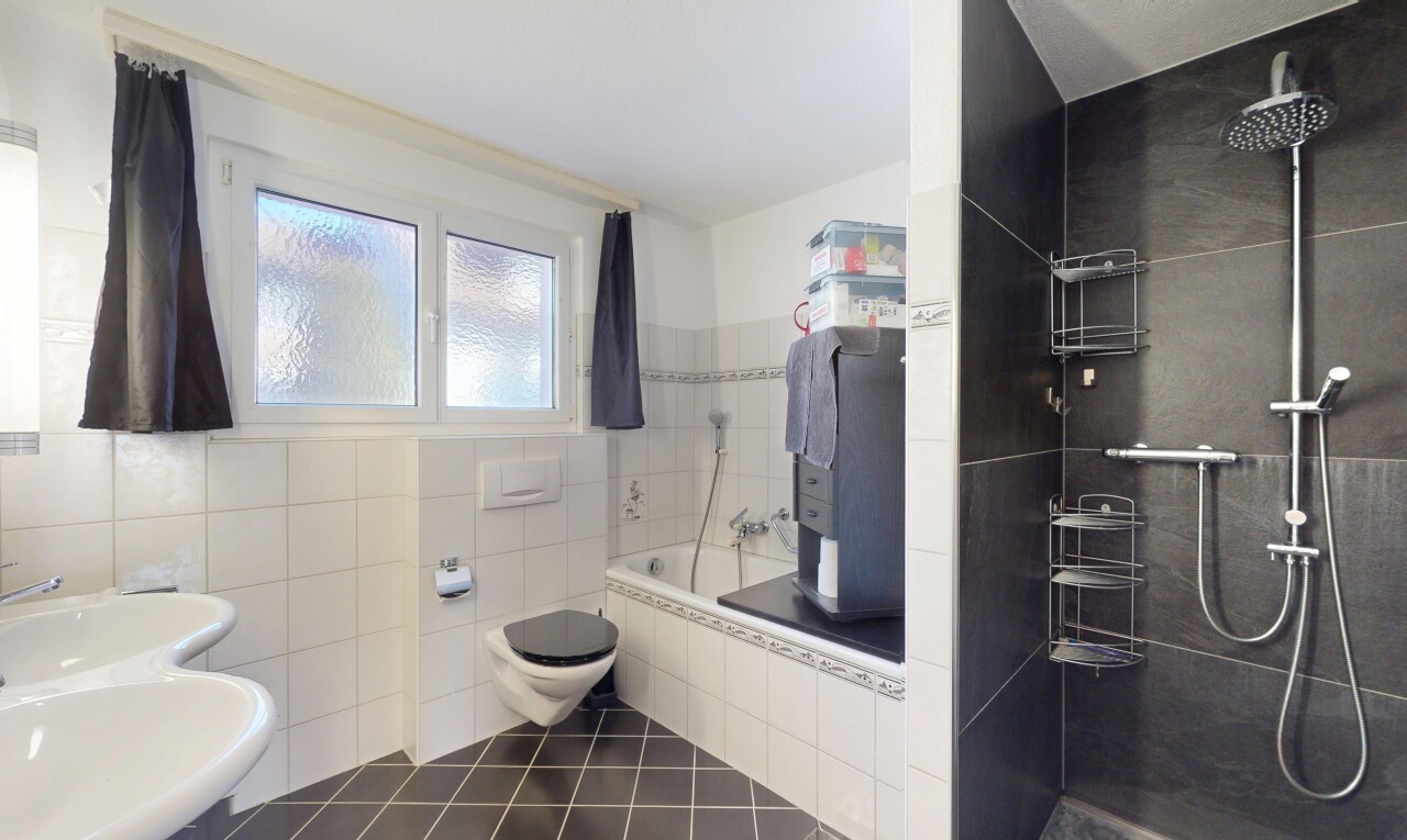 salle de bains avec lumière naturelle, sol en carrelage, bain, douche, et mur en carrelage