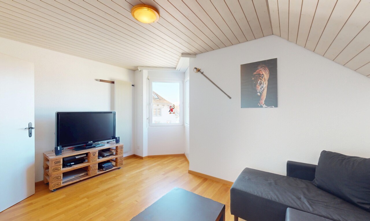 salon avec lumière naturelle, télévision, cloison sèche, plafond en bois, et sol en finition bois