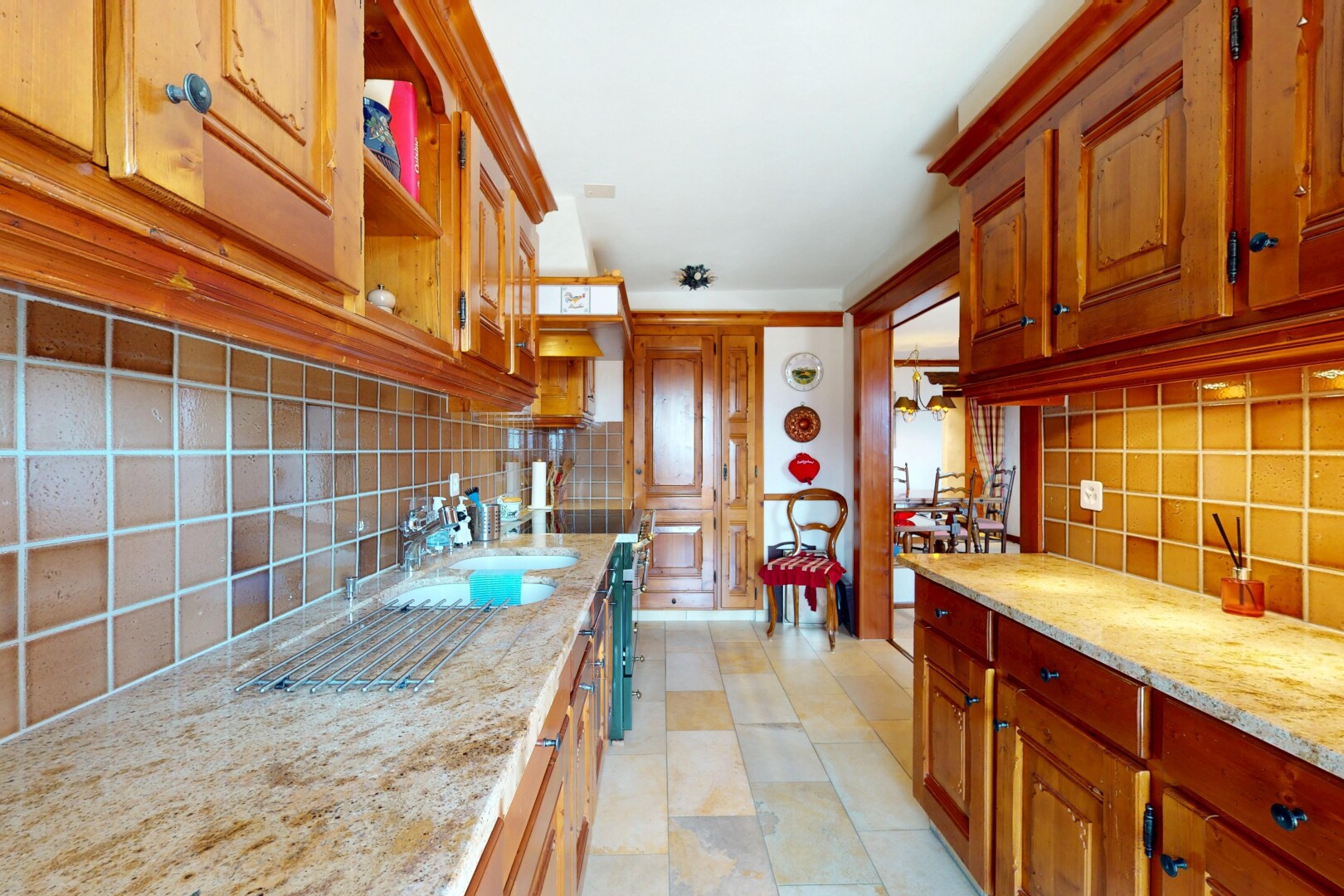 cuisine avec dosseret, backsplash, inside property, évier, et armoires élevées