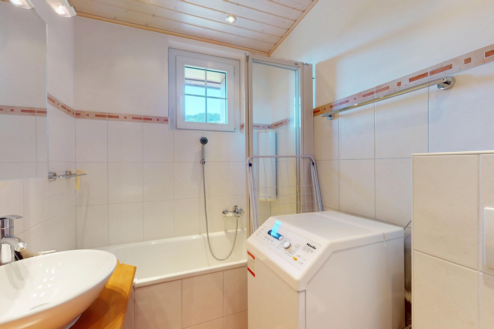 salle de bains avec évier, tile wall, mur en carrelage, natural light, et lumière naturelle