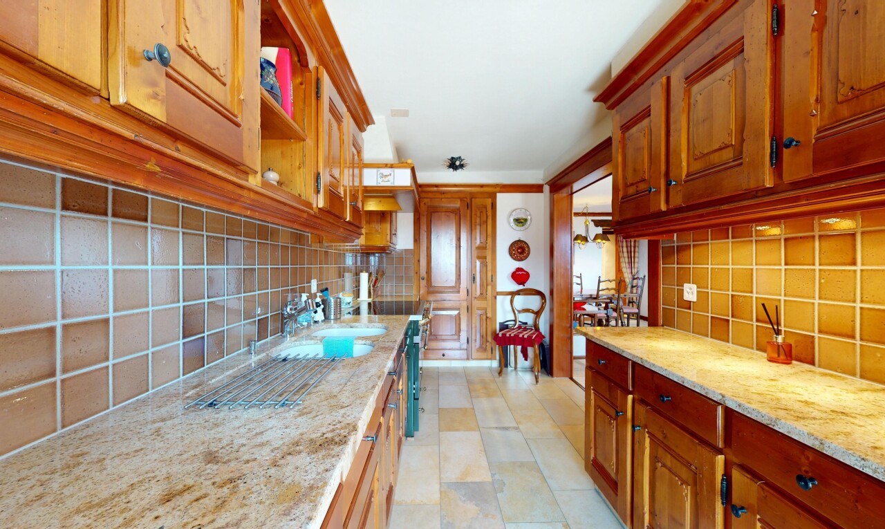 cuisine avec dosseret, backsplash, inside property, évier, et armoires élevées