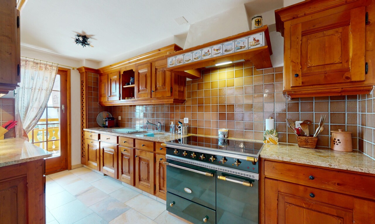 cuisine avec cuisinière, inside property, armoires élevées, armoires marron moyen, et backsplash