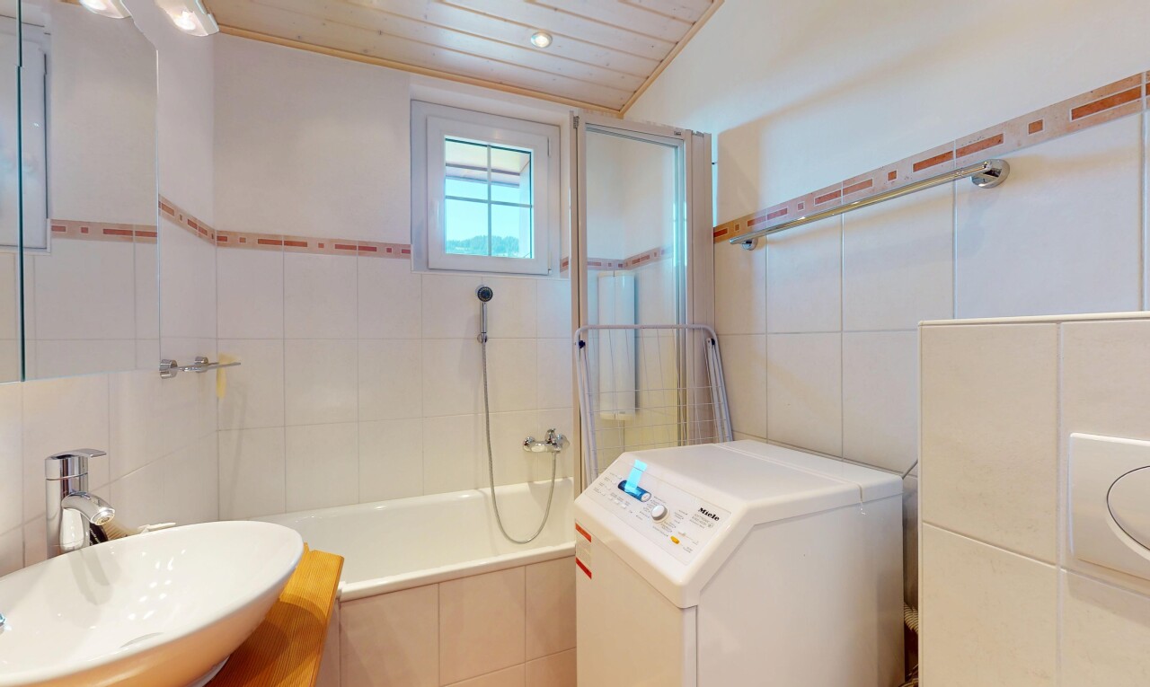 salle de bains avec évier, tile wall, mur en carrelage, natural light, et lumière naturelle