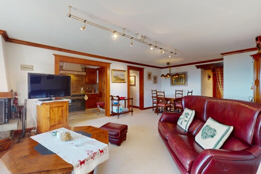 wohn- / esszimmer mit fernseher, crown molding, kronenstuck, inside property, und drywall