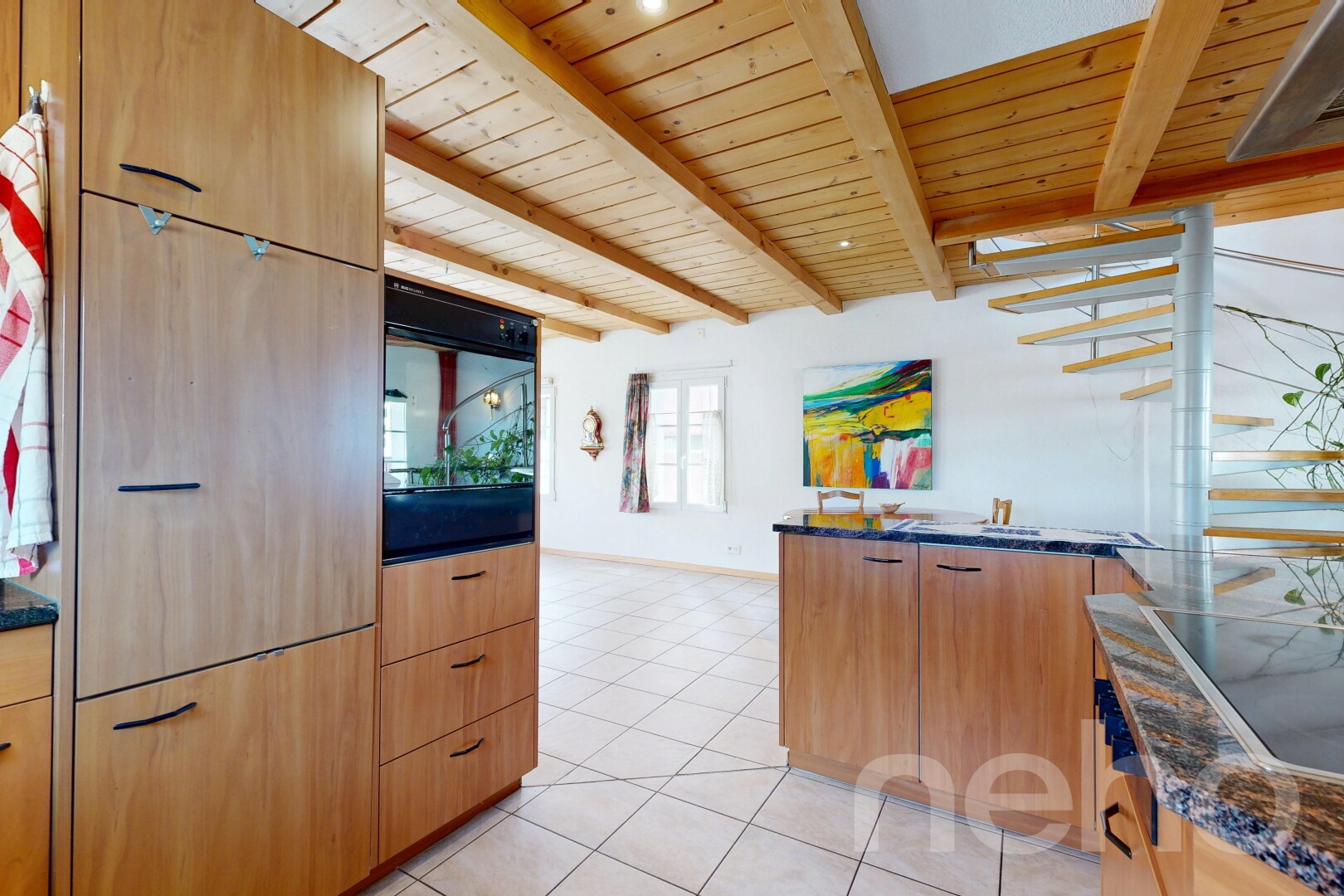 cuisine avec dark countertops, light floor, armoires marron clair, light brown cabinets, et cloison sèche