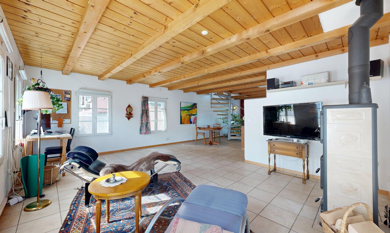 salon avec inside property, cloison sèche, drywall, télévision, et plafond en bois