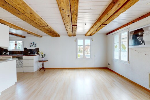 pièce vide avec plafond à poutres, beamed ceiling, inside property, light floor, et sol en finition bois