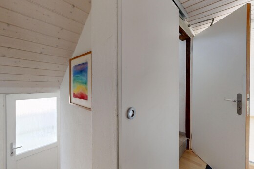 couloir avec inside property, vaulted ceiling, plafond voûté, et light floor