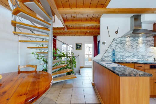 cuisine avec hotte, cloison sèche, drywall, dark countertops, et light floor