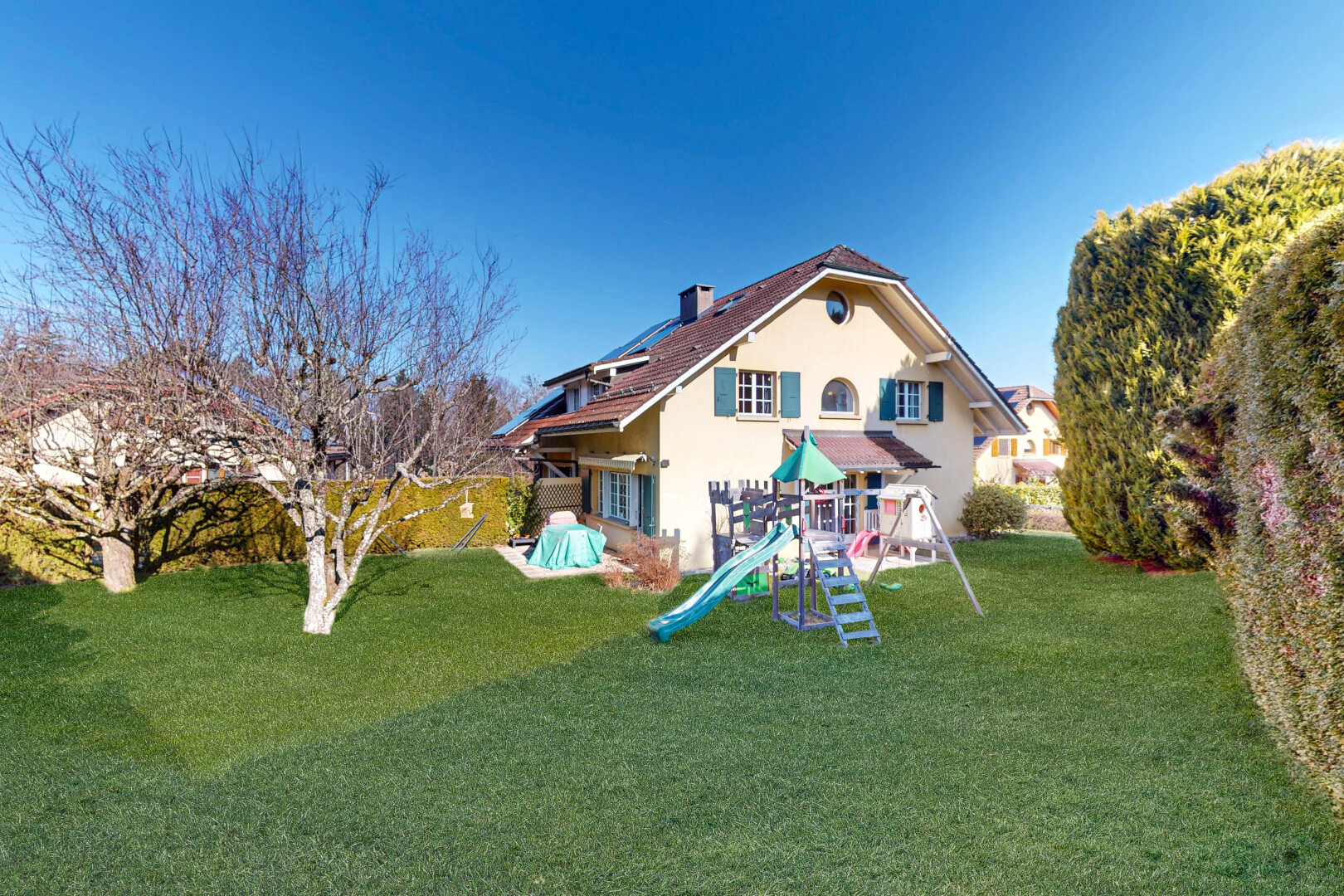 außenansicht mit spielplatz, rasen, property visible, stuckverkleidung, und day time