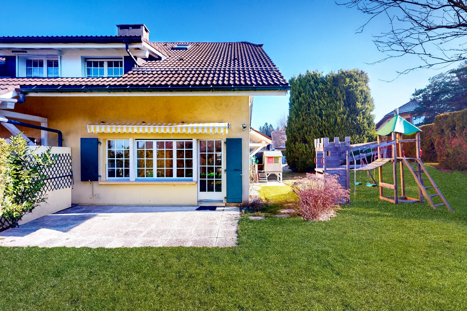 außenansicht mit rasen, terrasse, spielplatz, stuckverkleidung, und day time